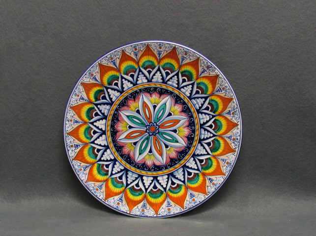 Piatto dipinto con Pavoncelle e decoro geometrico al centro ispirato dai motivi tradizionali della maiolica di Faenza.