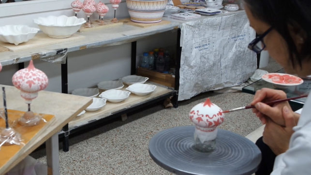 decoratrice al lavoro su una palla di natale in ceramica