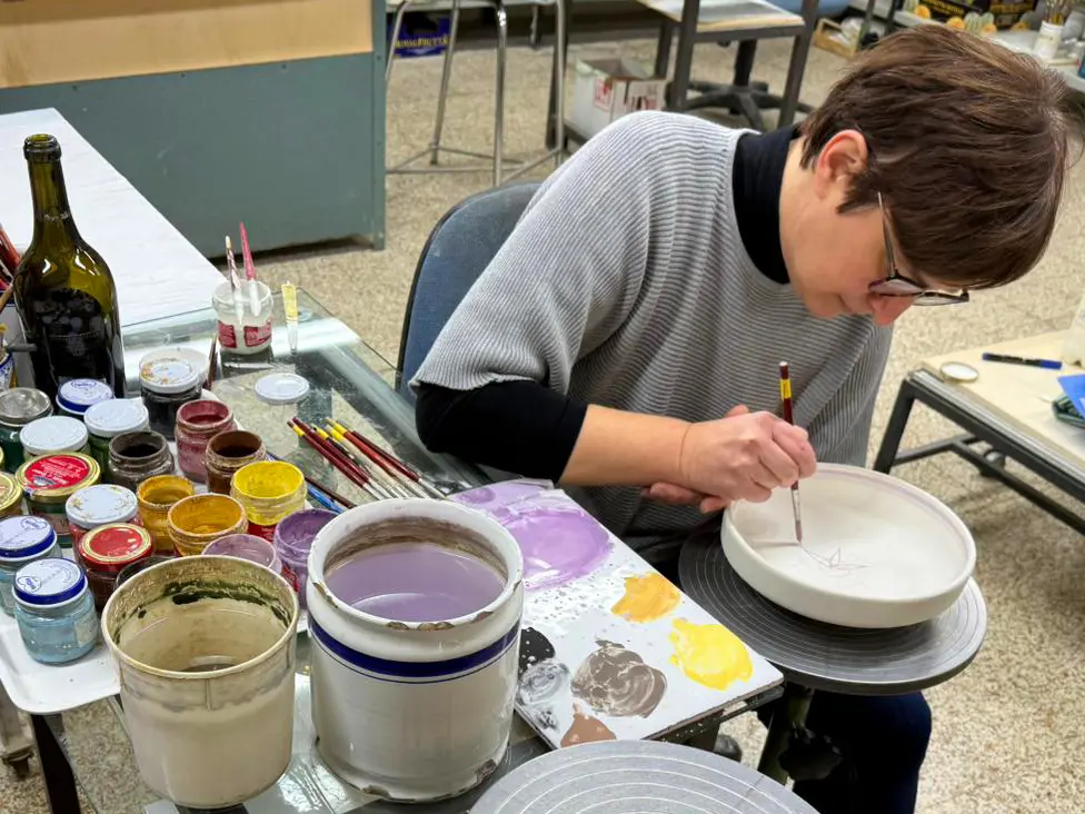 Elisa Suzzi decora una maiolica a La Vecchia Faenza